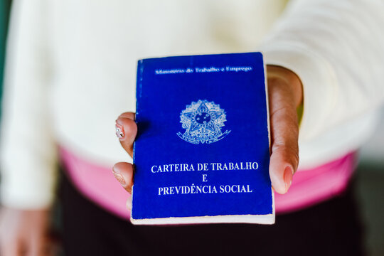 Woman holds his Brazilian document work and social security (Carteira de Trabalho e Previdencia Social).
