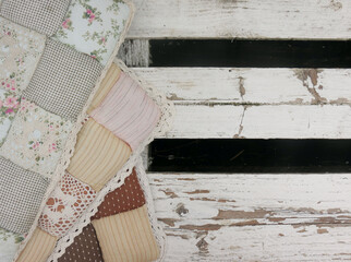 Soft pillows with floral print on a white wooden bench in the loft style on the street, close-up