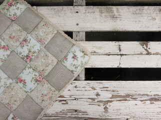 Soft pillows with floral print on a white wooden bench in the loft style on the street, close-up