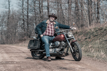 Fototapeta na wymiar Mid Adult Man Sitting On Motorcycle In Forest