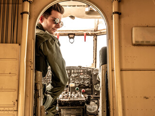 A handsome young pilot sitting in the cockpit