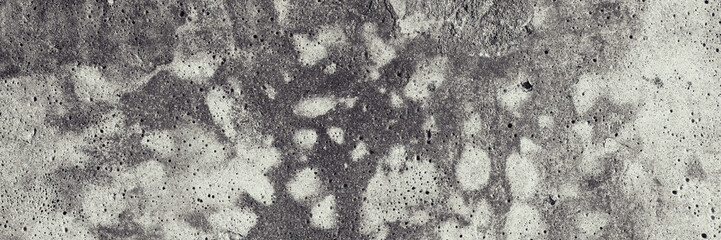 Texture of old concrete wall. Rough gray concrete surface with white spots. Wide panoramic background for design.