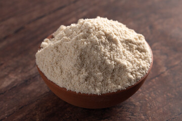 Bowl of Sprouted Sorghum Flour on a Dark Wood Background