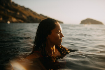 Girl watching the sunset in the sea