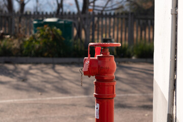 Red fire hydrant with a gren tank in the background