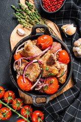 Pork kebab with tomato and pepper in a pan. Meat BBQ.  Black background. Top view