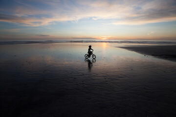 silhouette of child on bicycle 