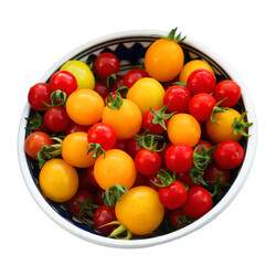 Yellow and red cherry organic tomatoes in a pottery bowl with white background