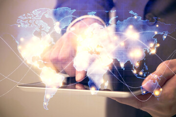 Double exposure of man's hands holding and using a phone and international business theme drawing.