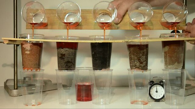 Colored water is poured trough 5 samples of soil:(l>r)sand, sandy soil, peat, humus and clay. The soil types ability to store and filter water (for pesticides) can be observed, clay needs a timelapse 
