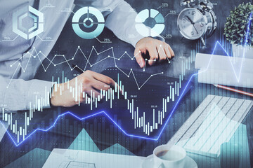 Double exposure of man's hands holding and using a phone and financial graph drawing. Analysis concept.