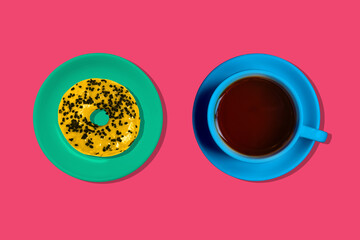 Yellow doughnut and a blue coffee Cup on a colored background. Creative minimal style
