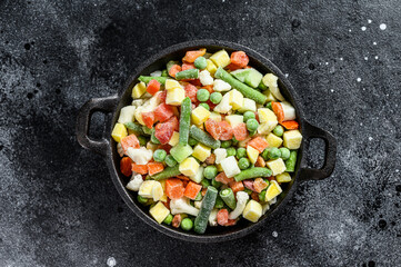 Frozen vegetables. broccoli, cherry tomatoes, corn, pea, carrot.  Black background. Top view