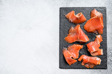 Slices of smoked salmon. Organic fish. White background. Top view. Copy space