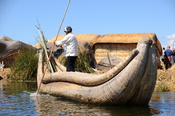 Uros fisherman rowing a reed boat next to his floating island