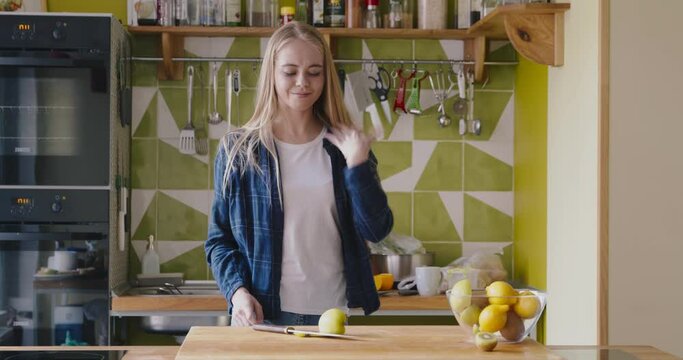 Woman cut her finger with knife while chopping fruit