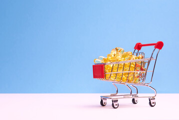Shopping trolley with pills and drugs on a blue background. Conceptually for healthcare, hospital, clinic and medical business.