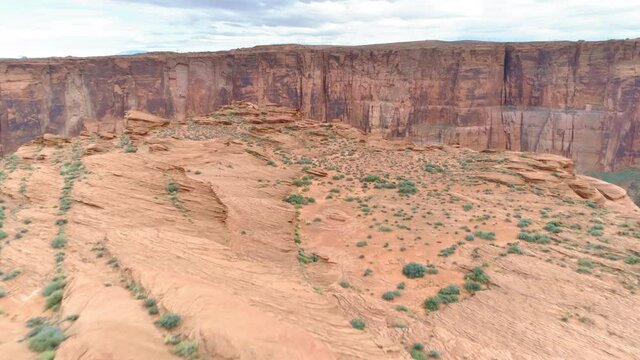4K aerial, drone shot, over drastic Horse Shoe Bend park, sandstone cliff with green Colorado river down below in the canyon. The red desert in Arizona on cloudy day. Park where begins Grand Canyon