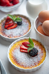 creme brulee with fruits and mint on white background