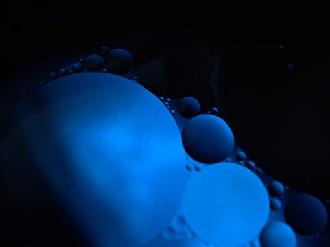 Closeup bubbles oil with balck blue light ,macro image ,blue christmas balls on black background, abstract background ,water drops shiny for card design