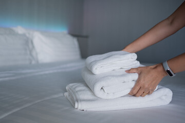cleaning hotel, bath towel on white bed, room service 
