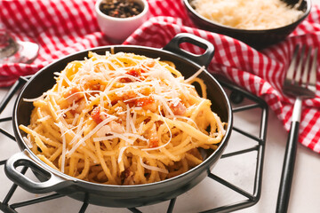 Frying pan with tasty pasta carbonara on table