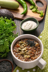 Cup of tasty lentils soup on table