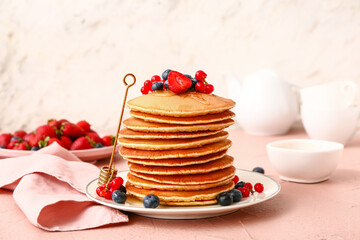 Sweet pancakes with berries on table