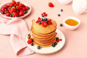 Sweet pancakes with berries on color background