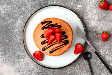 Sweet pancakes with berries on grey background