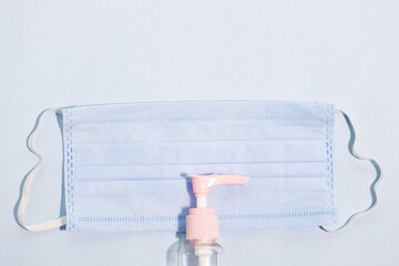 Closeup shot of the medical face mask and a hand sanitizer - the concept of coronavirus
