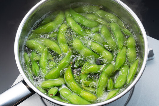 The edamame is being cooked in a pot.