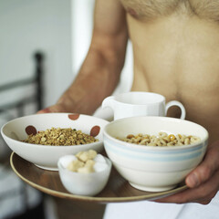Man holding a tray of breakfast