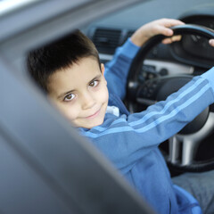 Boy sitting in the car holding the steering wheel