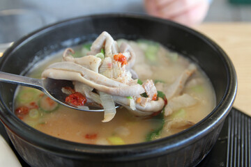 Korean pork rice soup (Dwaeji-gukbap) with the focus on pig stomach in a steaming stone bowl at Korean restaurant, Busan, South Korea
