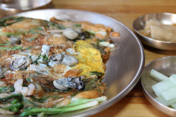 Focus on oyster on the Korean pancake with the leek and egg at Korean restaurant, Busan, South Korea