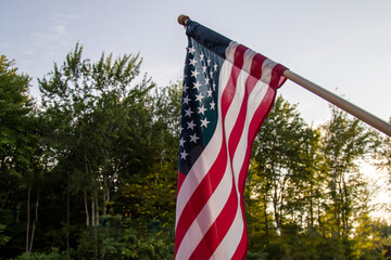 stars and stripes, looking out at the American flag, woods and forest in the background