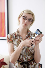 Woman cutting her credit card with scissors