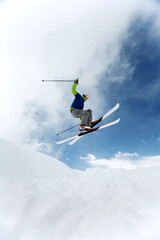 Naklejka na ściany i meble Man doing a mid air ski jump off a mountain