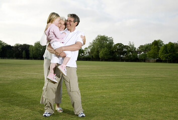 Senior man and woman with a girl having fun in the park
