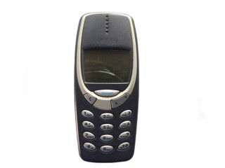 Old gray color mobile phone with keypad on white background