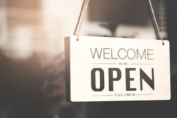 Welcome open sign on shop door. Text on cafe front or restaurant hang on door at entrance. vintage tone style.