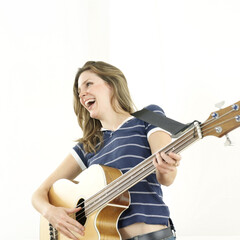 Woman laughing while playing guitar