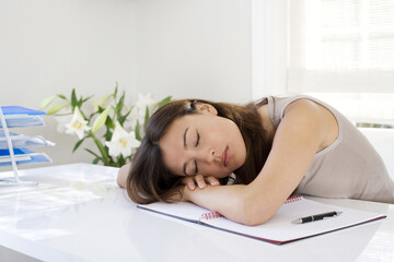 Obraz na płótnie Canvas Woman lying down on desk in a home office