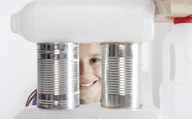 Girl looking through stacked recyclable items