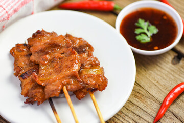 Grilled pork skewer with sauce on white plate / Pork satay Thai and Indonesian food menu Asian