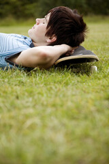 Boy resting on the grass with his eyes closed