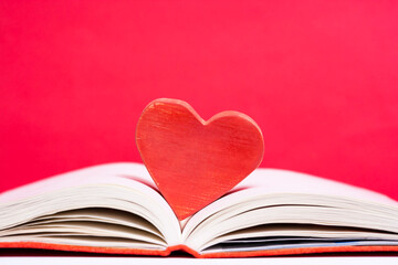 Books and heart shape wooden piece.