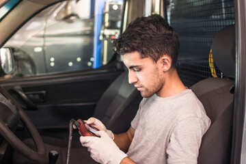 Auto mechanic using car scanner diagnostic tool