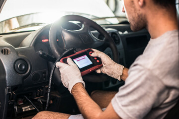 Auto mechanic using car scanner diagnostic tool